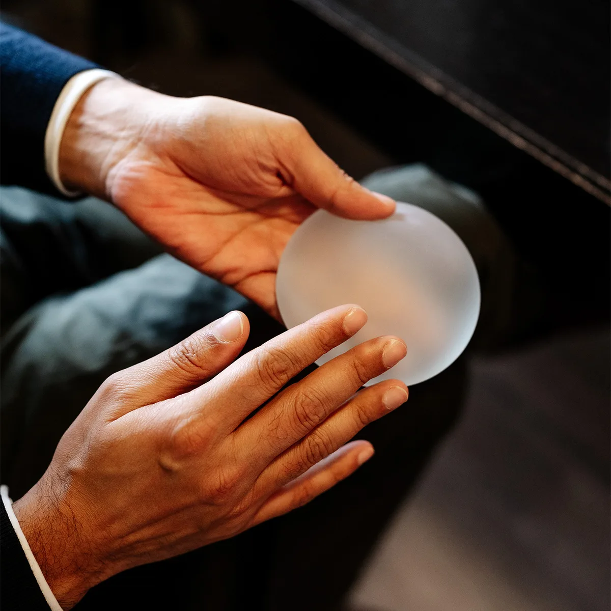 Mr Aadil Khan holding a breast implant during a consultation